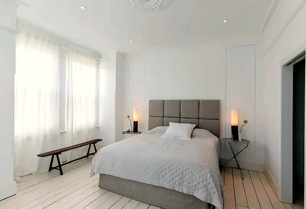 A bright bedroom with a made bed