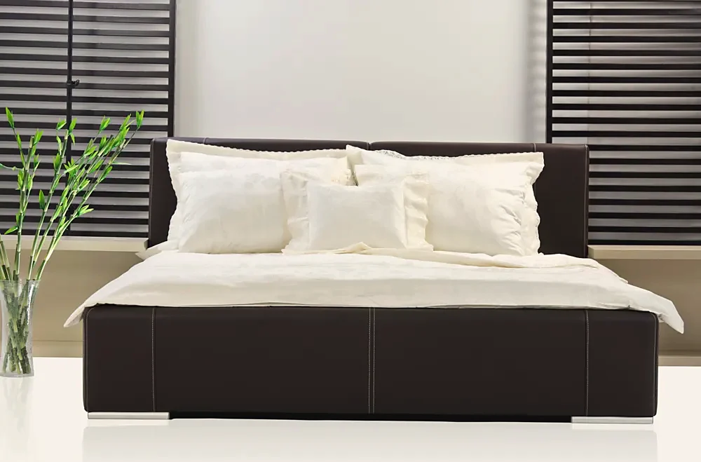 A modern bedroom with a dark ottoman bed